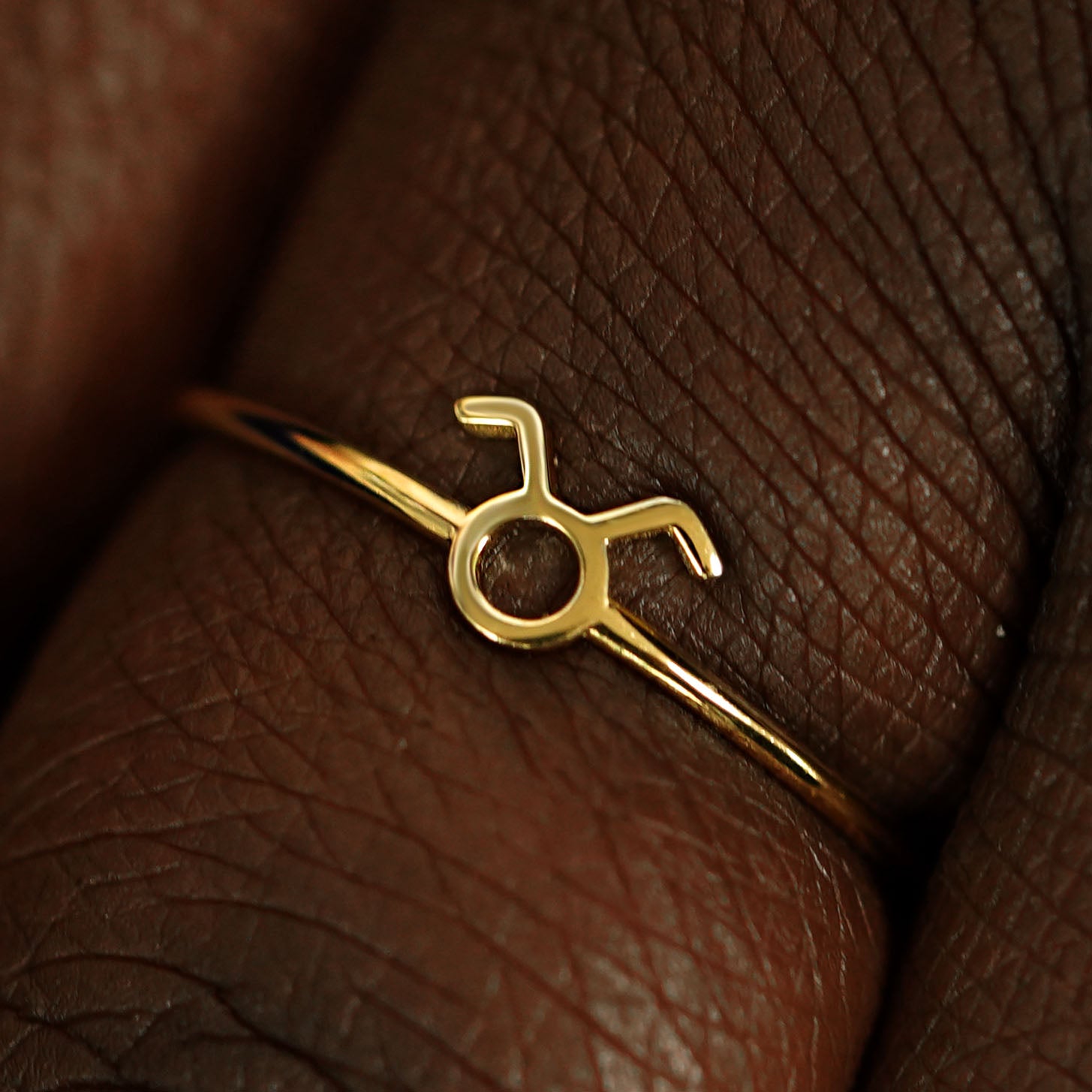 Close up view of a model's fingers wearing a 14k yellow gold Taurus Horoscope Ring