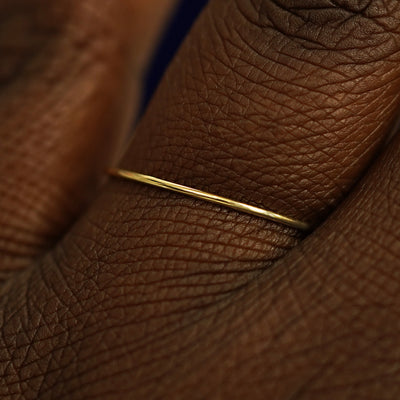 Close up view of a model's fingers wearing a 14k yellow gold Line Ring