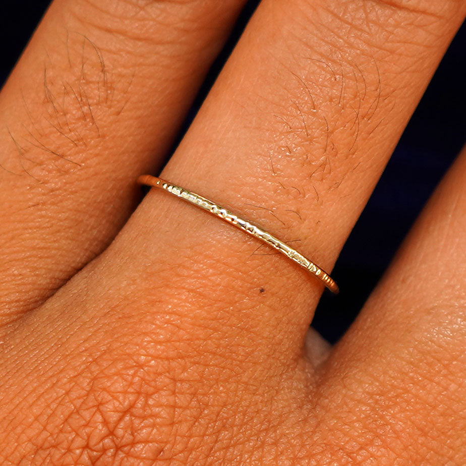 Close up view of a model's hand wearing a solid gold Shimmer Ring