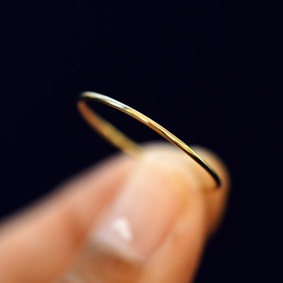 A model holding a Line Ring tilted to show the side of the ring