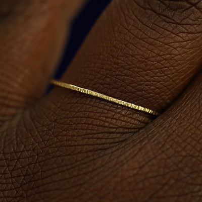 Close up view of a model's fingers wearing a 14k yellow gold Shimmer Ring