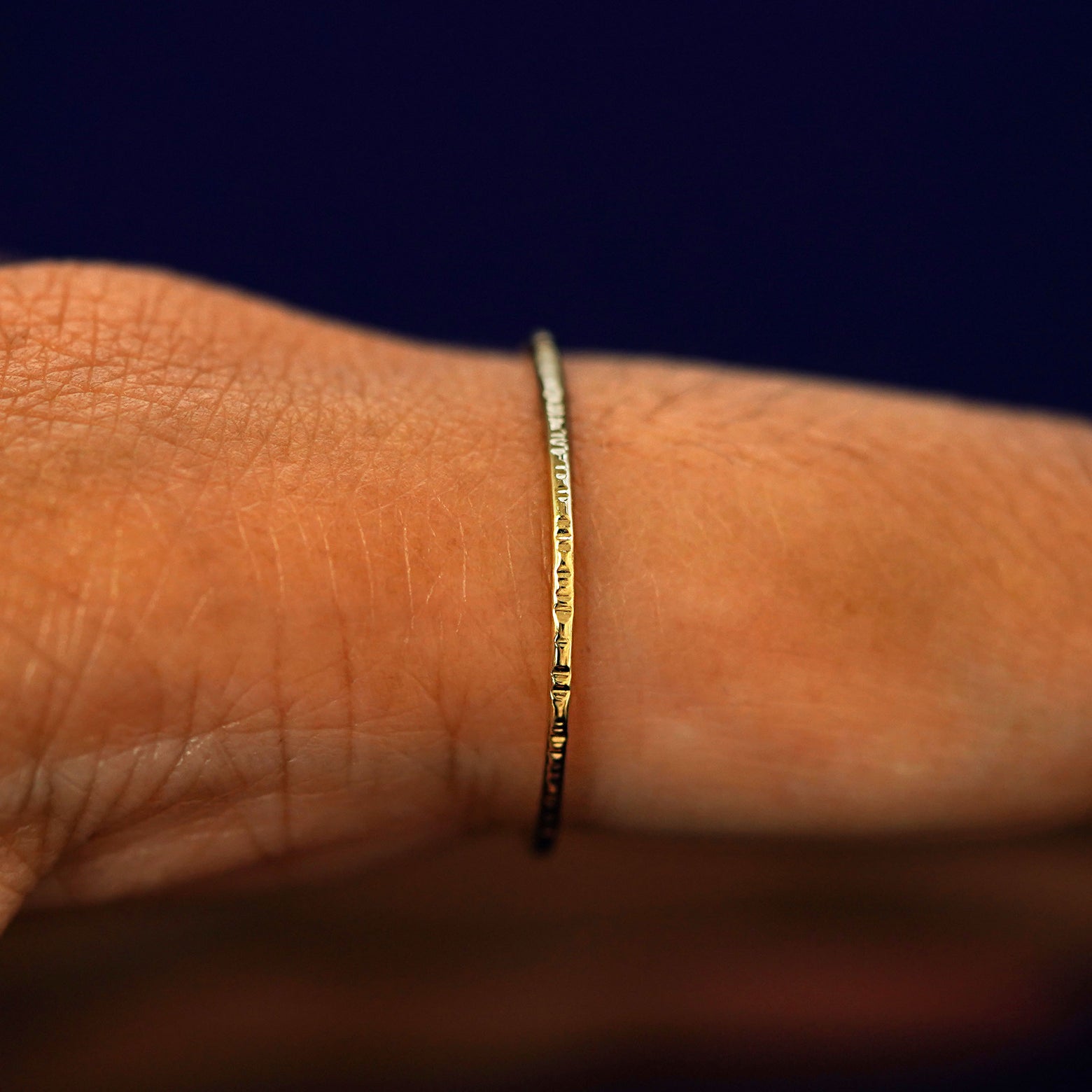 Side view of a Shimmer Ring on a model's finger