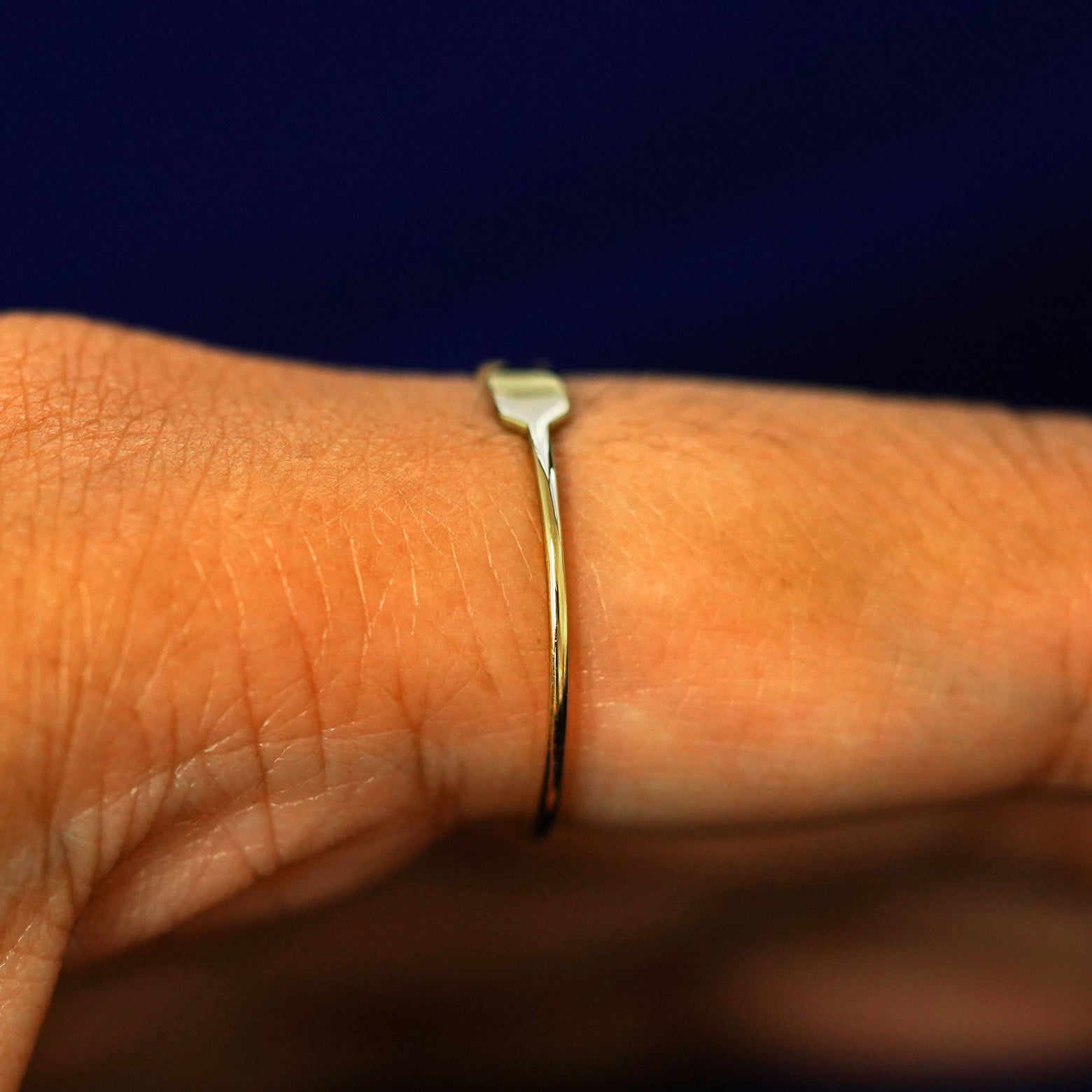 Side view of a Tanlah Ring on a model's finger