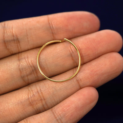 A yellow gold Zig Zag Ring in a model's hand showing the thickness of the band