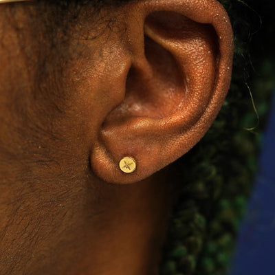 A model's ear wearing a solid yellow gold Star Earring