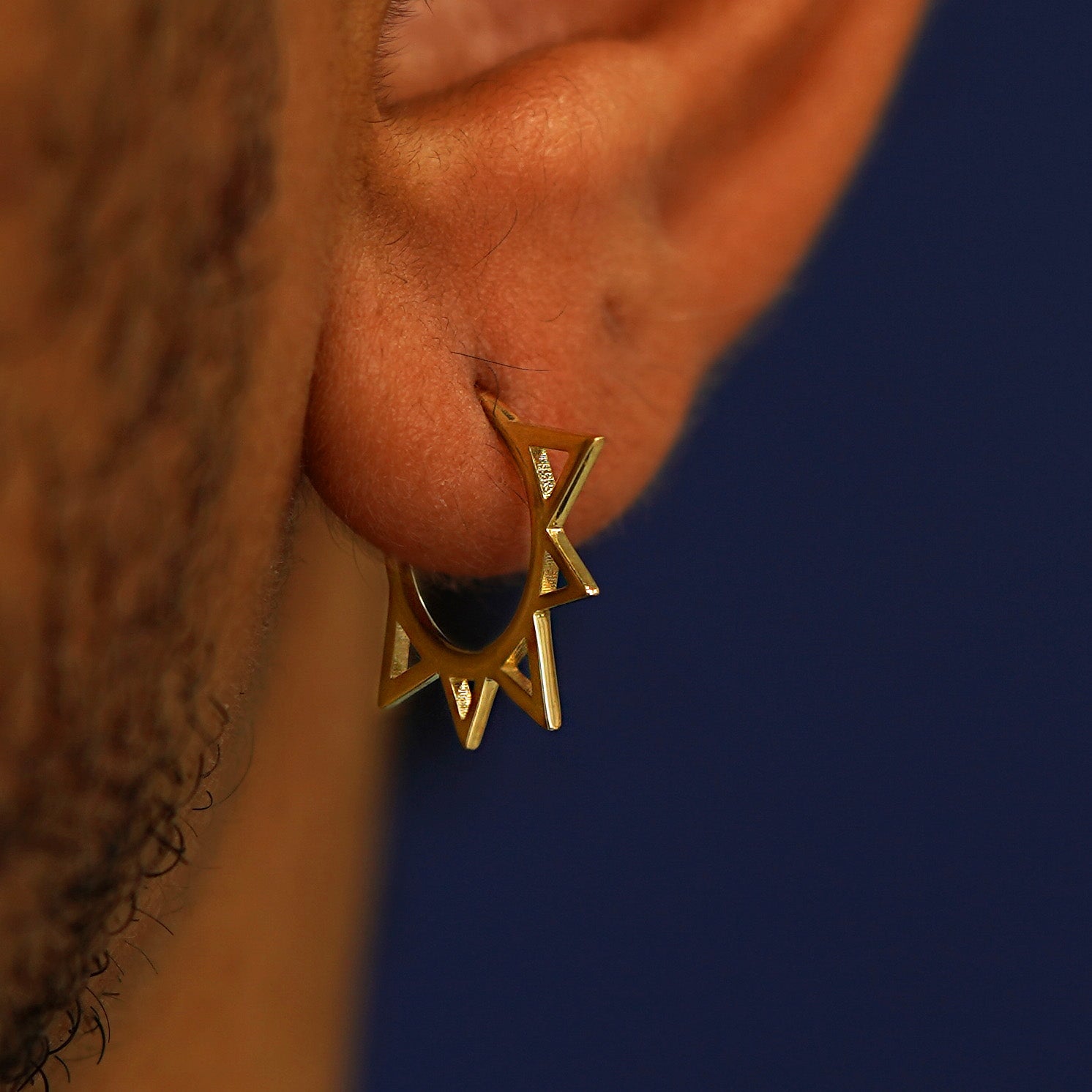 Close up view of a model's ear wearing a Sun Septum as a hoop earring