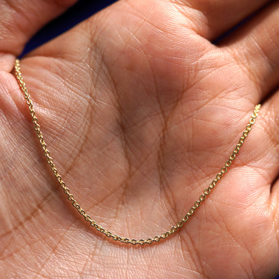 A yellow gold Thick Cable Bracelet draped on a model's palm