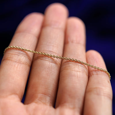 A yellow gold Thick Cable Bracelet resting on a model's fingers