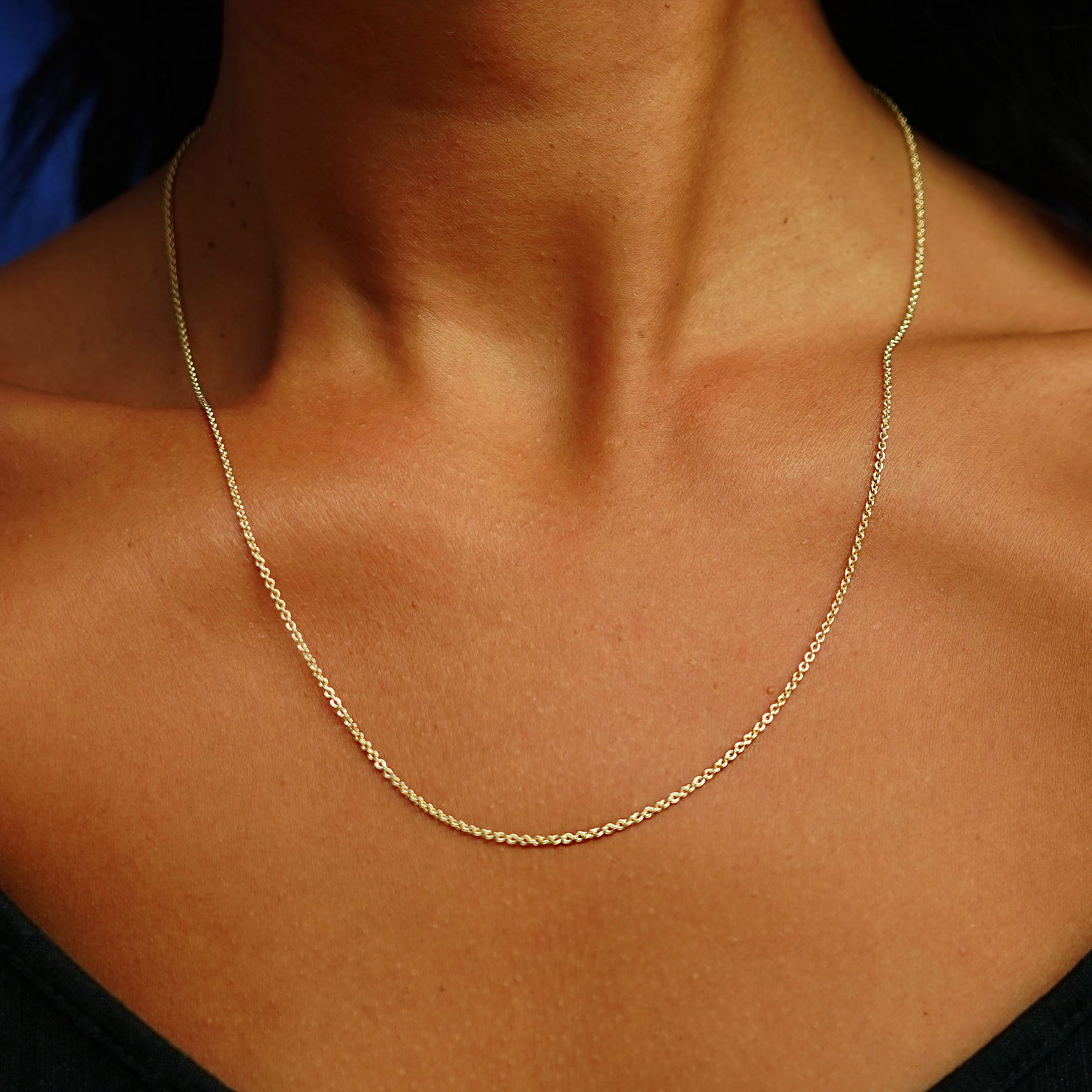 Close up view of a model's neck wearing a solid 14k yellow gold Thick Cable Chain