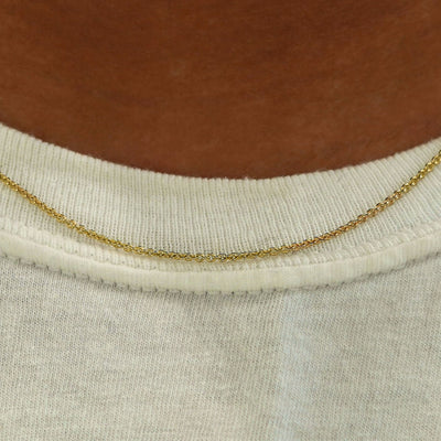 Close up view of a model's neck wearing a yellow gold Thick Cable Chain