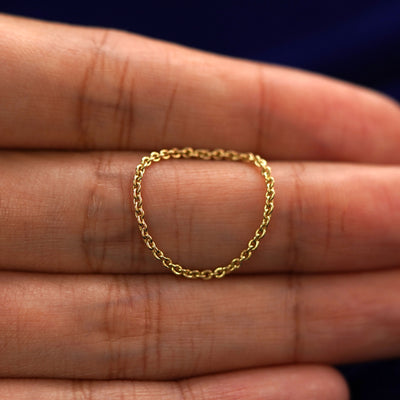 A yellow gold Thick Cable Ring draped over a model's finger to show the flexibility of the chain