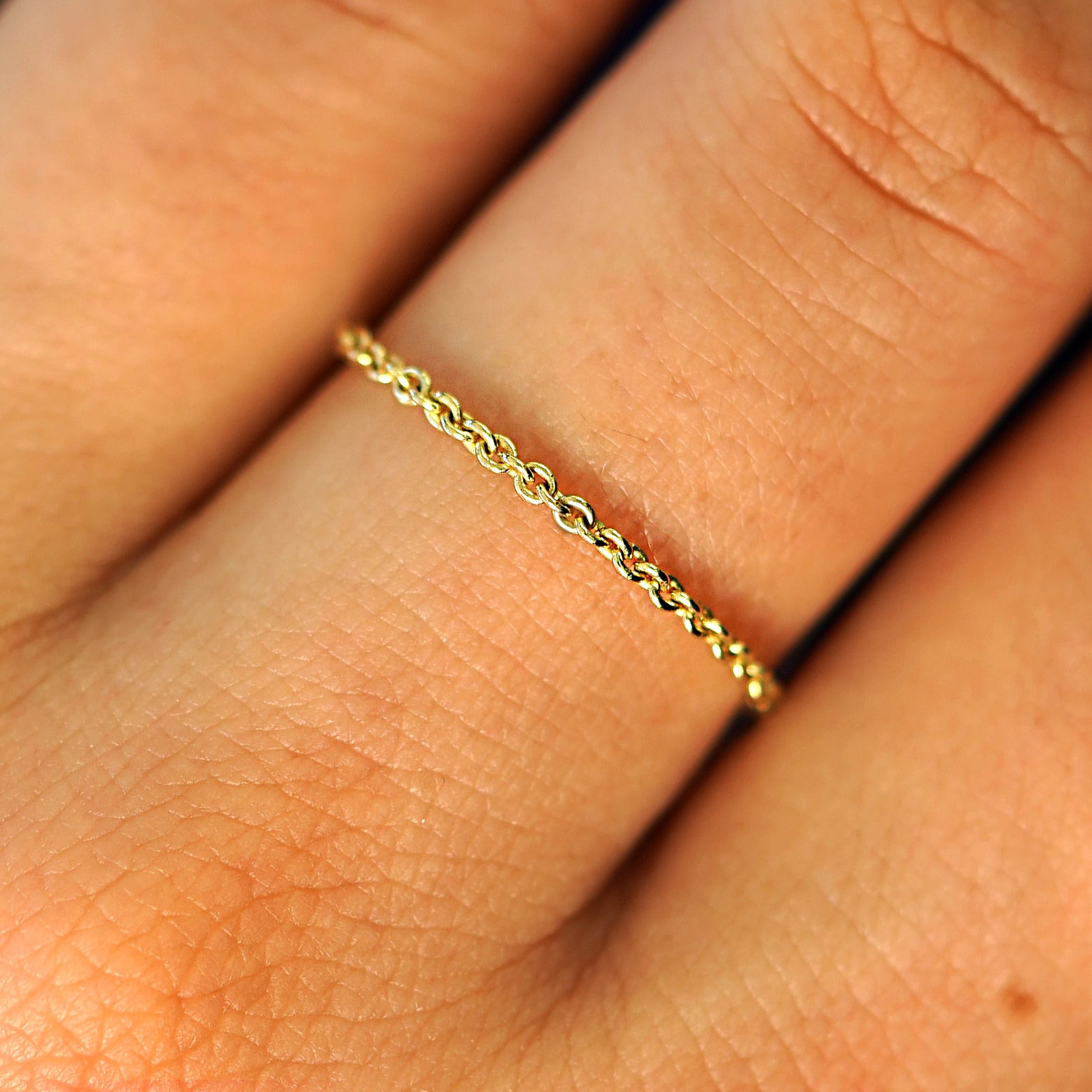 Close up view of a model's fingers wearing a 14k yellow gold Thick Cable Ring