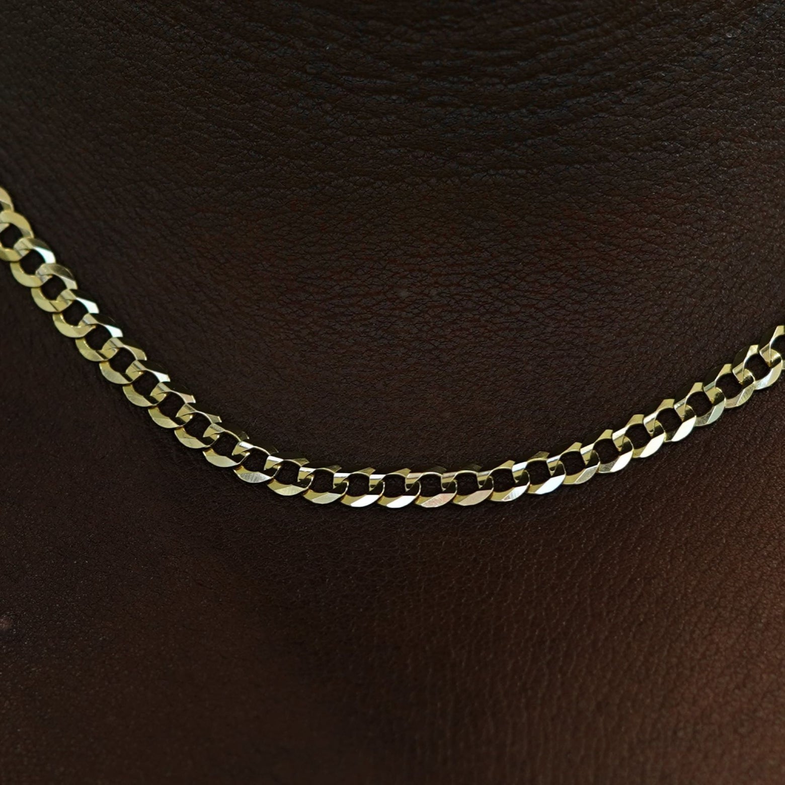 Close up view of a model's neck wearing a solid 14k gold Curb Chain