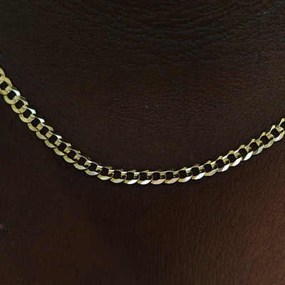 Close up view of a model's neck wearing a solid 14k gold Curb Chain