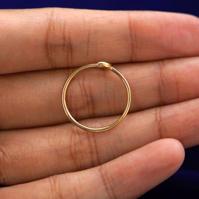 A yellow gold Moon Ring in a model's hand showing the thickness of the band