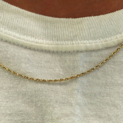 Close up view of a model's neck wearing a solid yellow gold Rope Chain