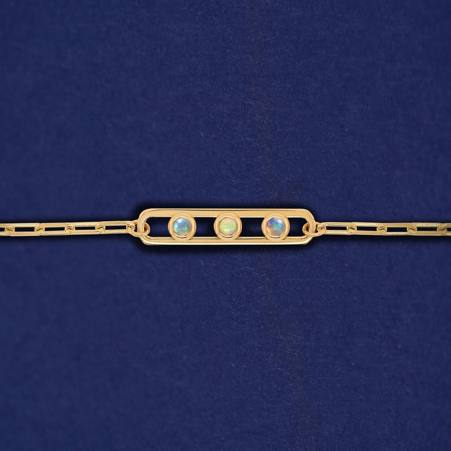 A yellow gold elongated open oval link with three bezel set Opals inside on a 14k gold Butch chain bracelet