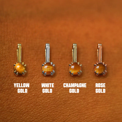 Four versions of the Tiger Eye Charm shown in options of yellow, white, rose, and champagne gold