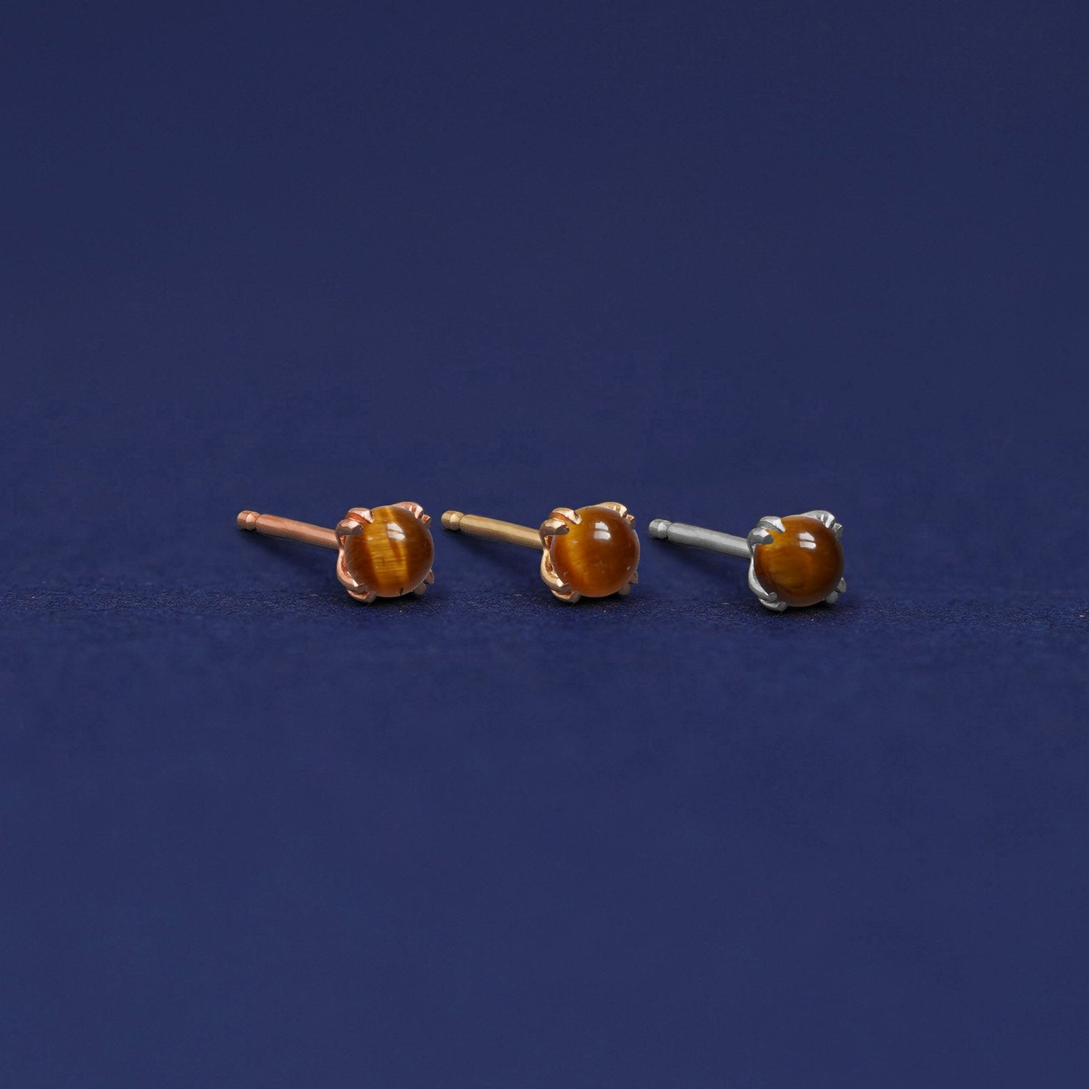 Three versions of the Tiger Eye Earring shown in options of rose, yellow, and white gold