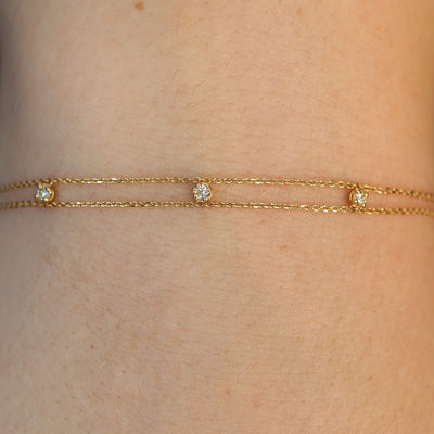 Close up view of a model's wrist wearing a solid gold 3 Diamond Cable Bracelet