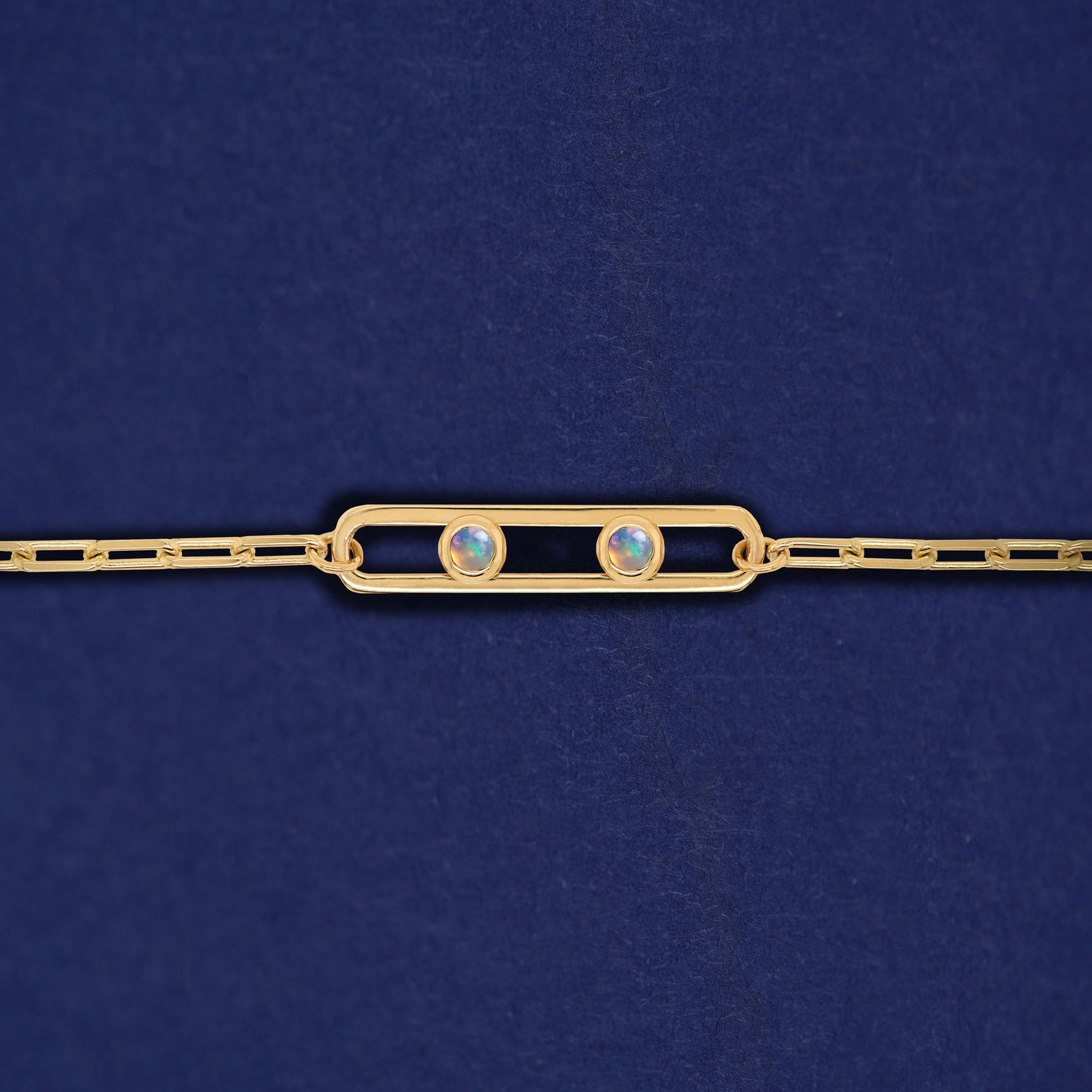 A yellow gold elongated open oval link with two bezel set Opals inside on a 14k gold Butch chain bracelet