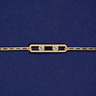 A yellow gold elongated open oval link with two bezel set Opals inside on a 14k gold Butch chain bracelet