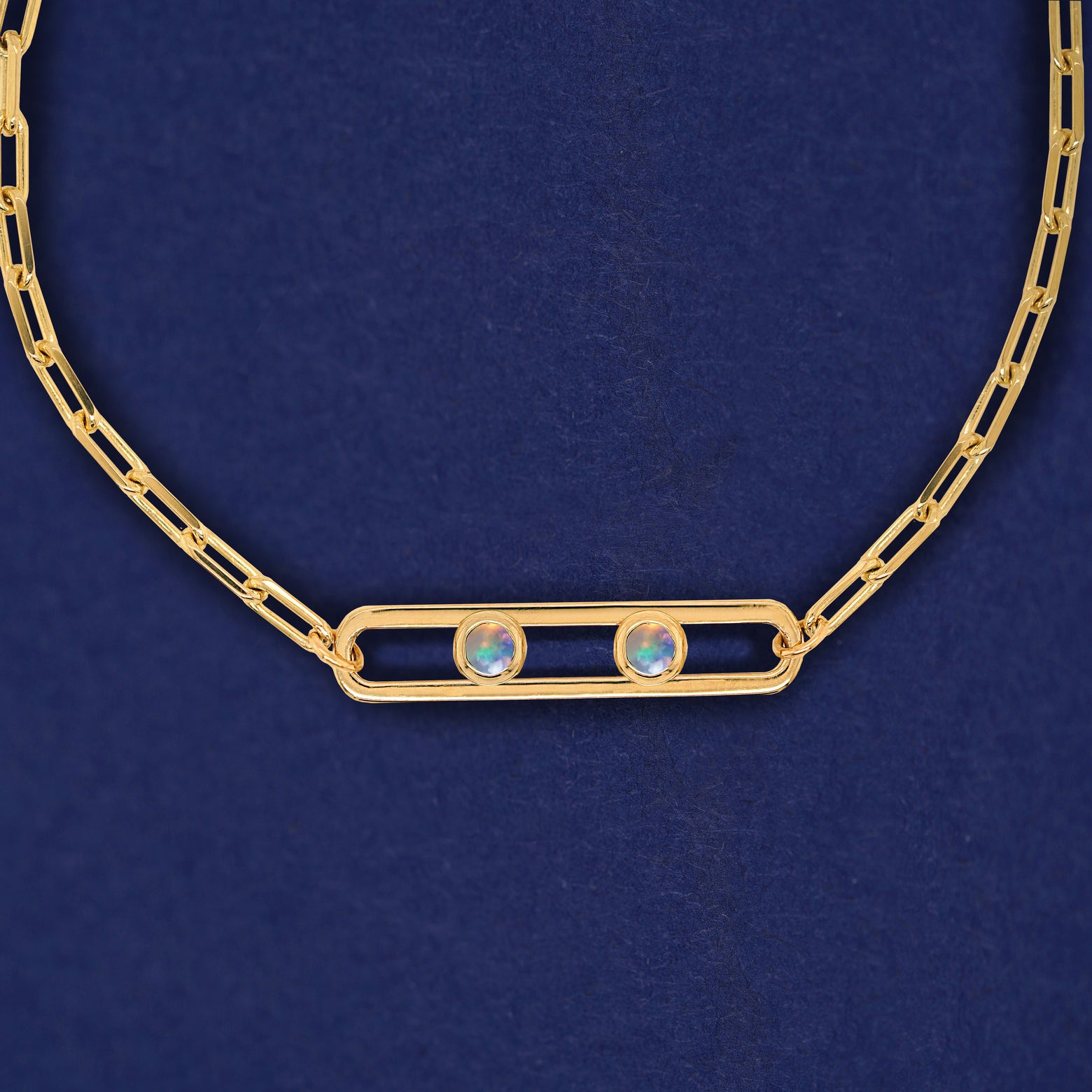 A yellow gold elongated open oval link with two bezel set Opals inside on a 14k gold Butch chain necklace