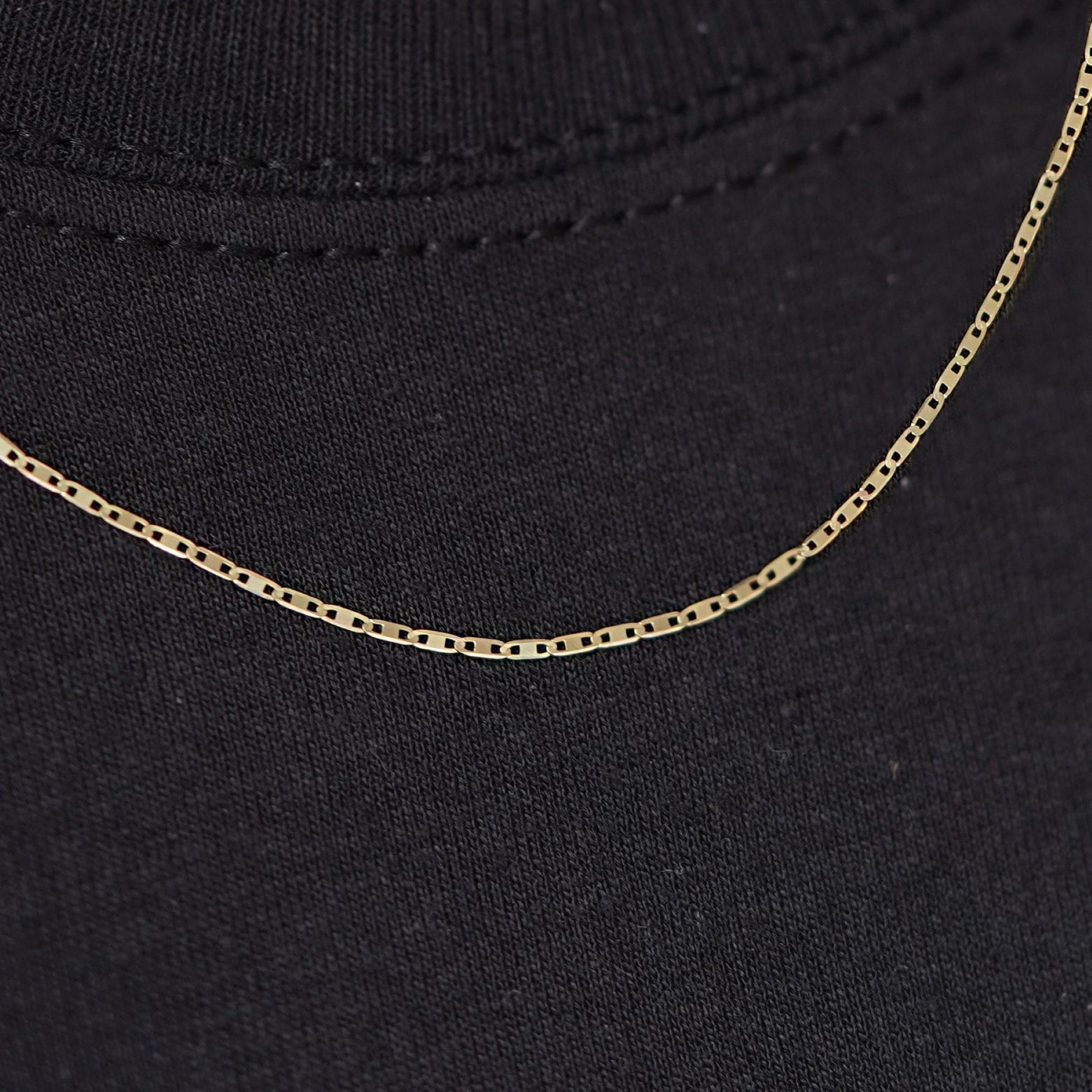 Close up view of a model wearing a 14k yellow gold Valentine Chain