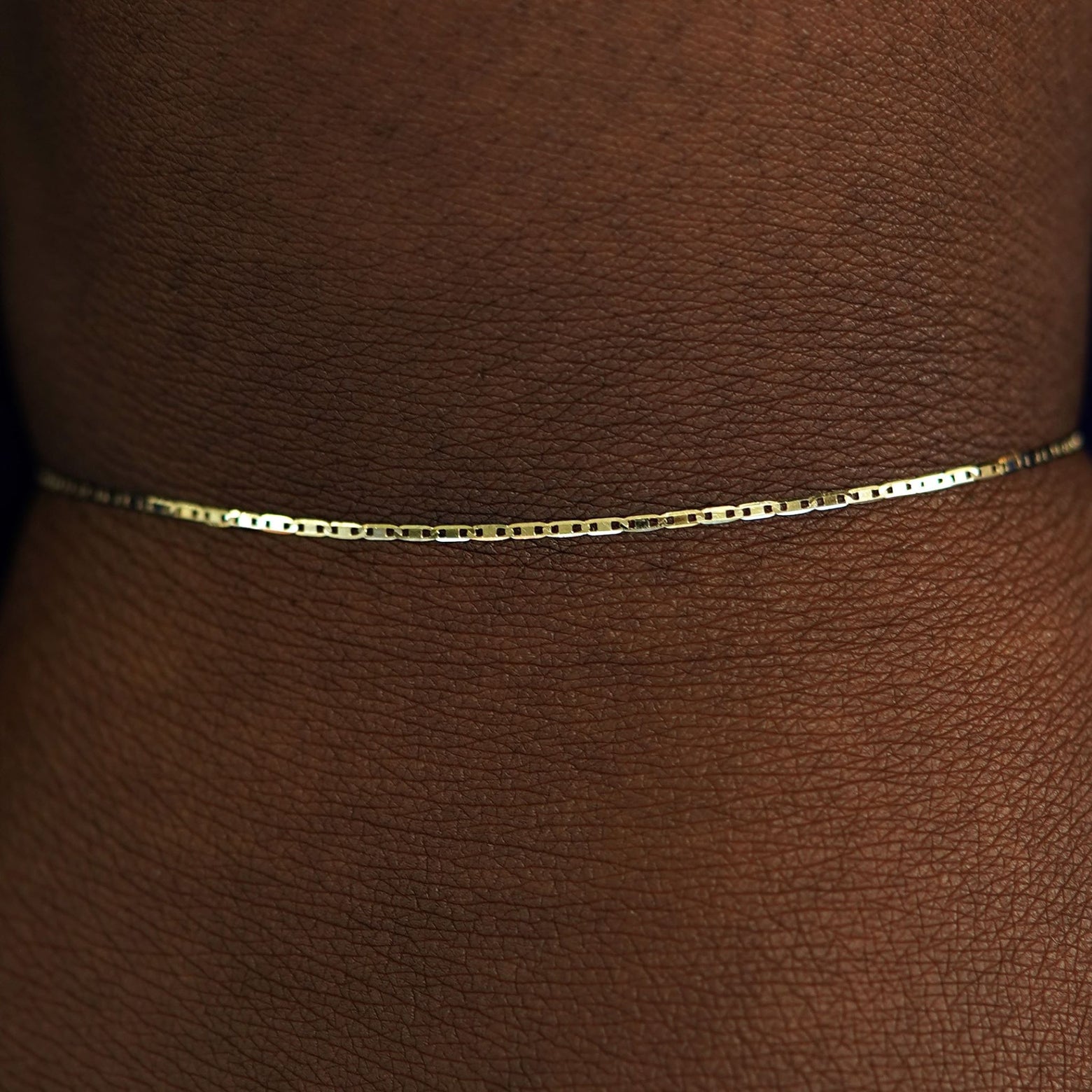 Close up view of a model's wrist wearing a yellow gold Valentine Bracelet