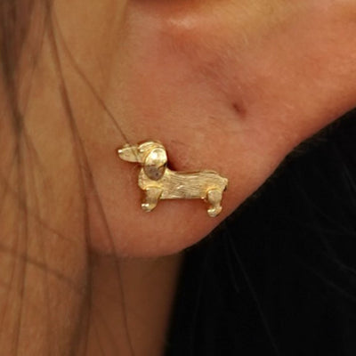 Close up view of a model's ear wearing a yellow gold Dog Earring