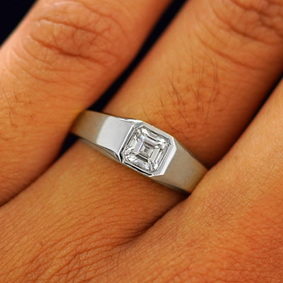 Close up view of a model's fingers wearing a white gold white Asscher Moissanite Signet Ring