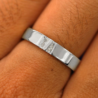 Close up view of a model's hand wearing a solid white gold Double Baguette Diamond Band