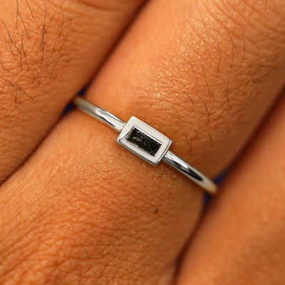 Close up view of a model's fingers wearing a 14k white gold Baguette Salt and Pepper Diamond Ring