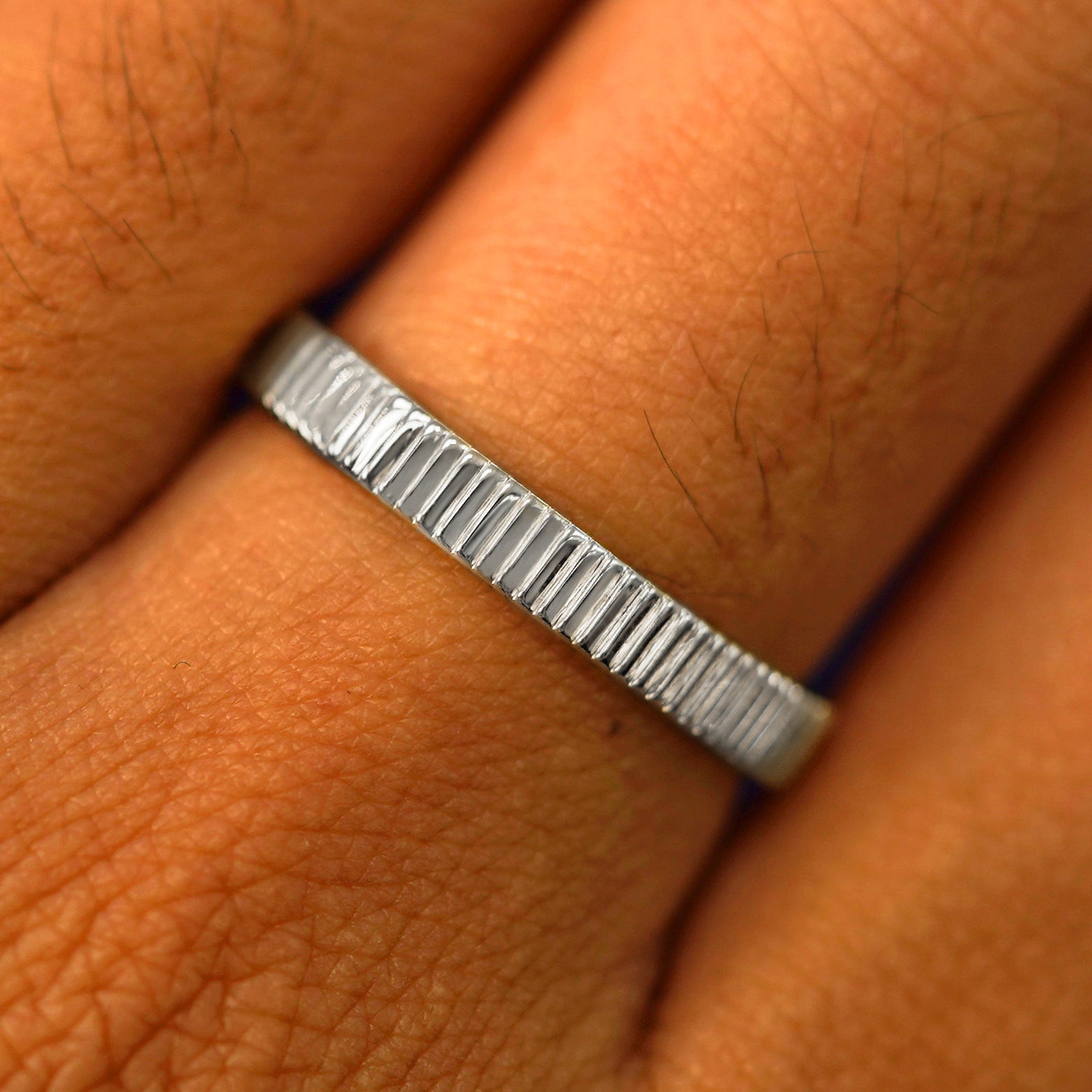 Close up view of a model's fingers wearing a 14k white gold Edge Band