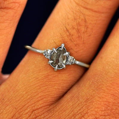 Close up view of a model's fingers wearing a 14k white gold Pear Salt and Pepper Diamond Ring