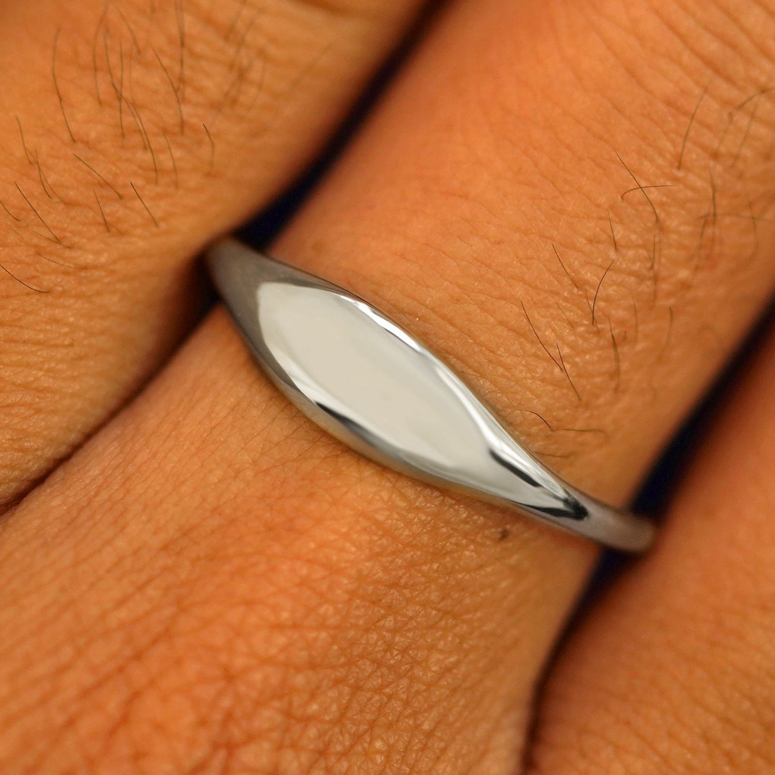 Close up view of a model's fingers wearing a 14k white gold Puffy Elongated Signet Ring