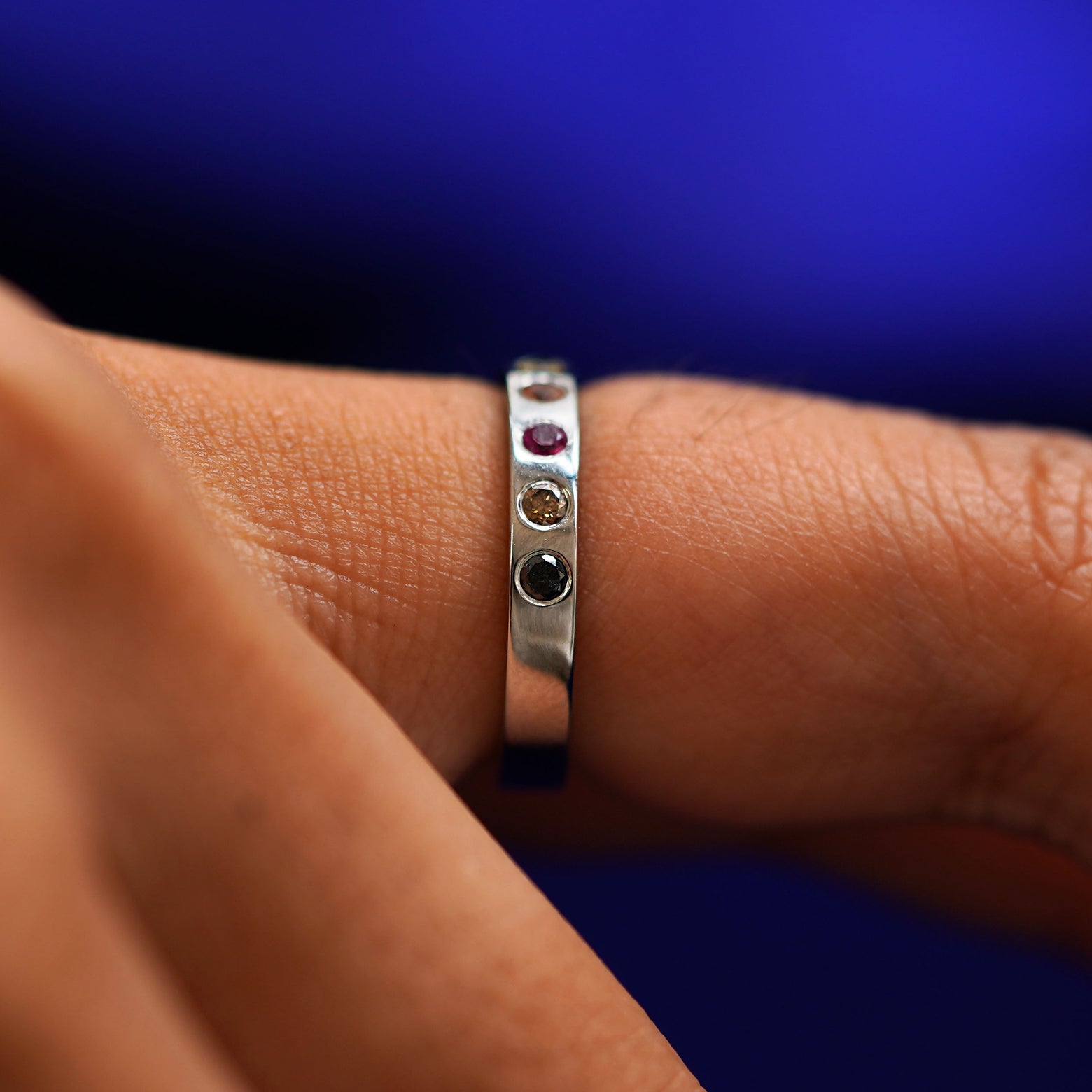 Side view of a Rainbow Band on a model's finger