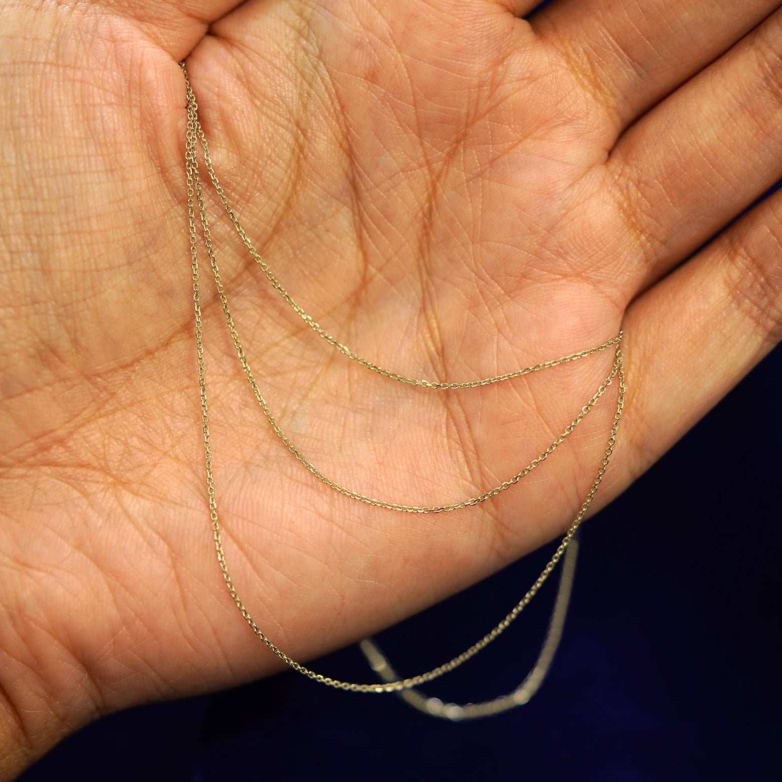 A model holding a Cable Infinity chain draped loosely over their palm 3 times