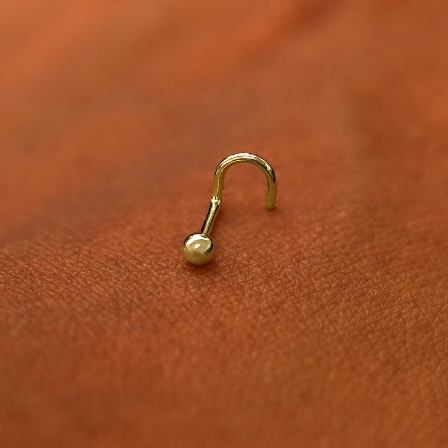 A yellow gold Ball Nose Stud laying on the back of a model's hand