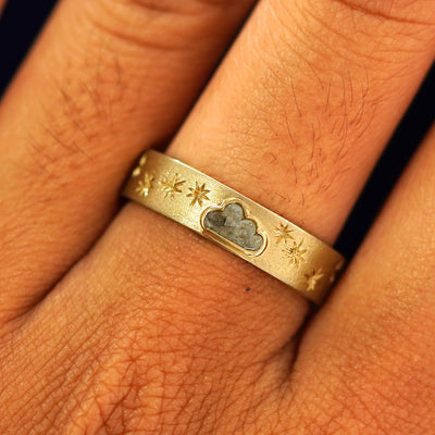 Close up view of a model's fingers wearing a 14k yellow gold Cloud Diamond Band