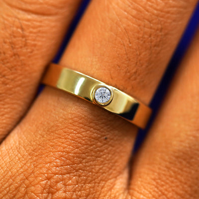 Close up view of a model's fingers wearing a 14k yellow gold Diamond Industrial Band