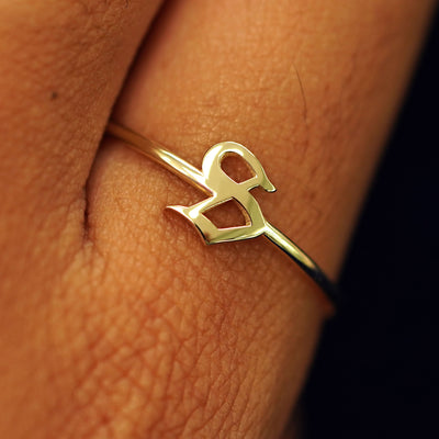 Close up view of a model's fingers wearing a 14k yellow gold Initial Ring with the letter S