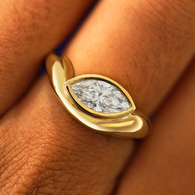 Close up view of a model's fingers wearing a 14k yellow gold Marquise Lab Diamond Melted Ring