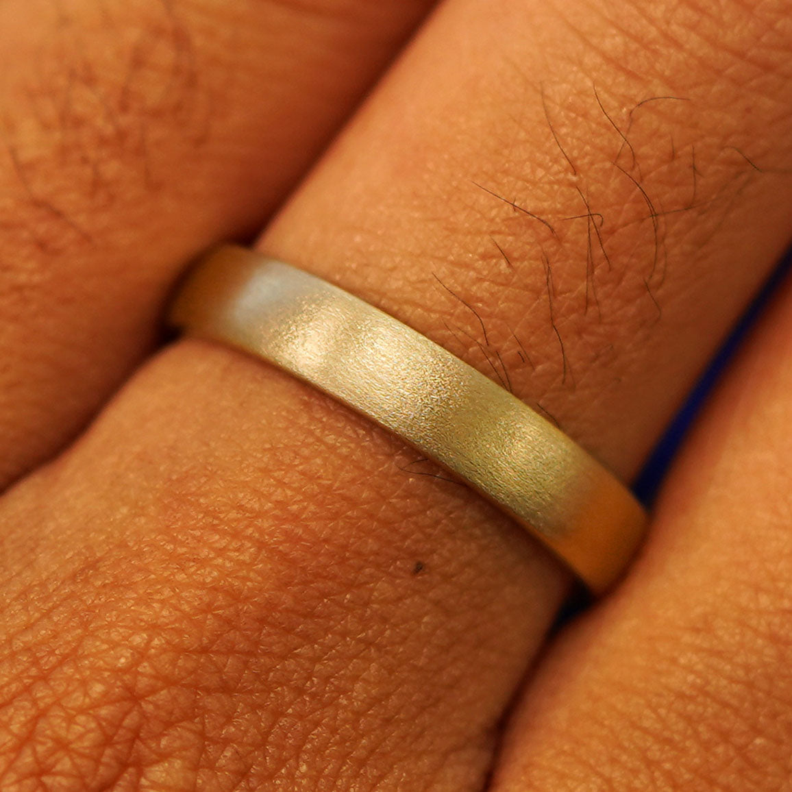 Close up view of a model's fingers wearing a 14k yellow gold Mix Matte Band