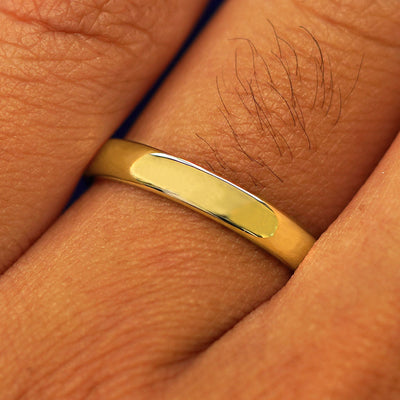 Close up view of a model's fingers wearing a 14k yellow gold Mix Mirror Band