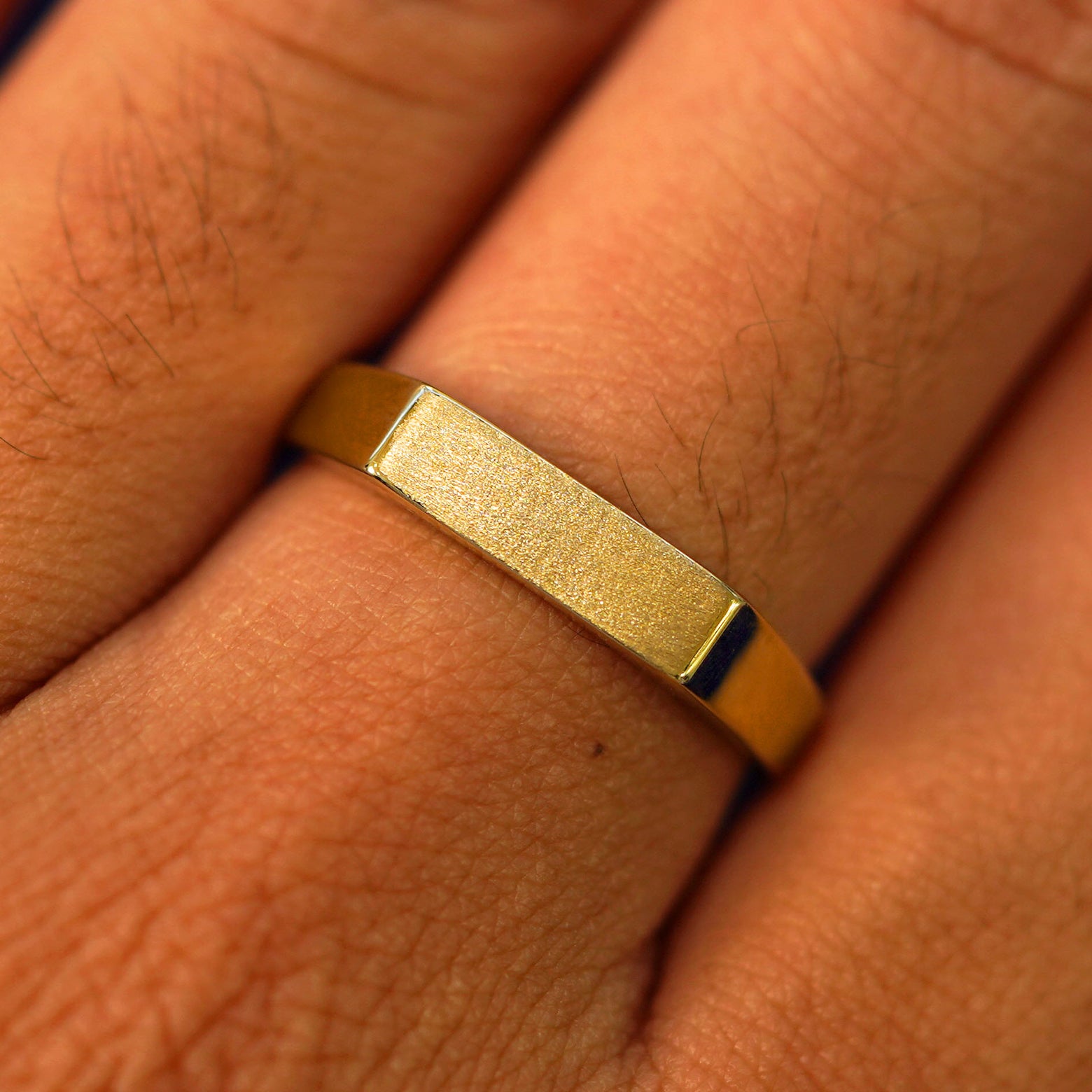 Close up view of a model's fingers wearing a 14k yellow gold Rectangular Signet Ring