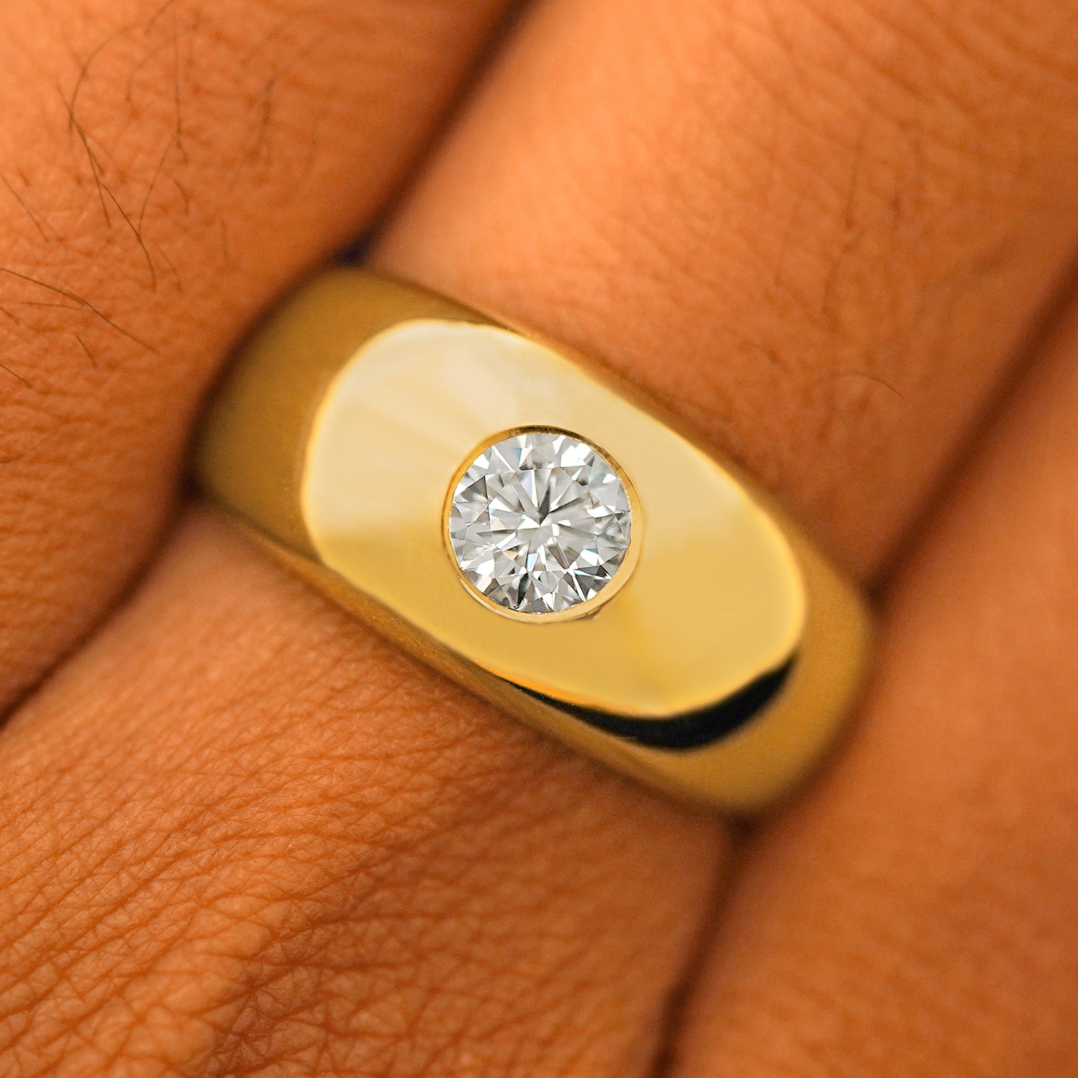 Close up view of a model's fingers wearing a 14k yellow gold Round Lab Diamond Puffy Signet Ring