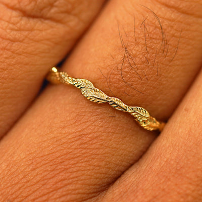 Close up view of a model's fingers wearing a 14k yellow gold Thin Leaves Band