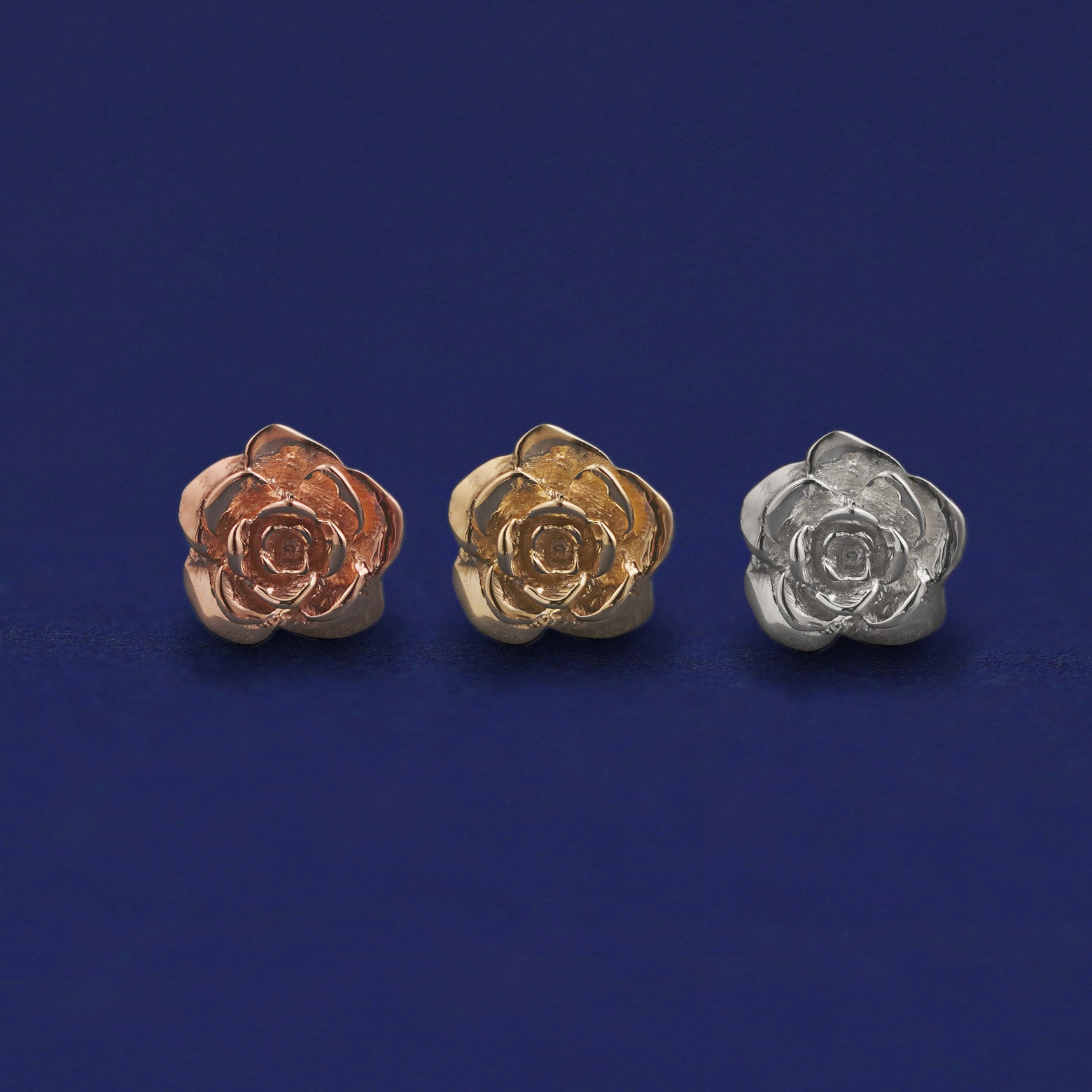 Three versions of a Rose Earring shown in options of rose, yellow, and white gold
