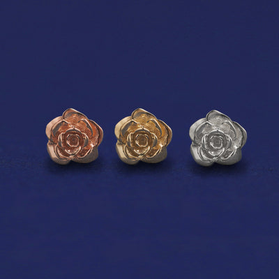 Three versions of a Rose Earring shown in options of rose, yellow, and white gold